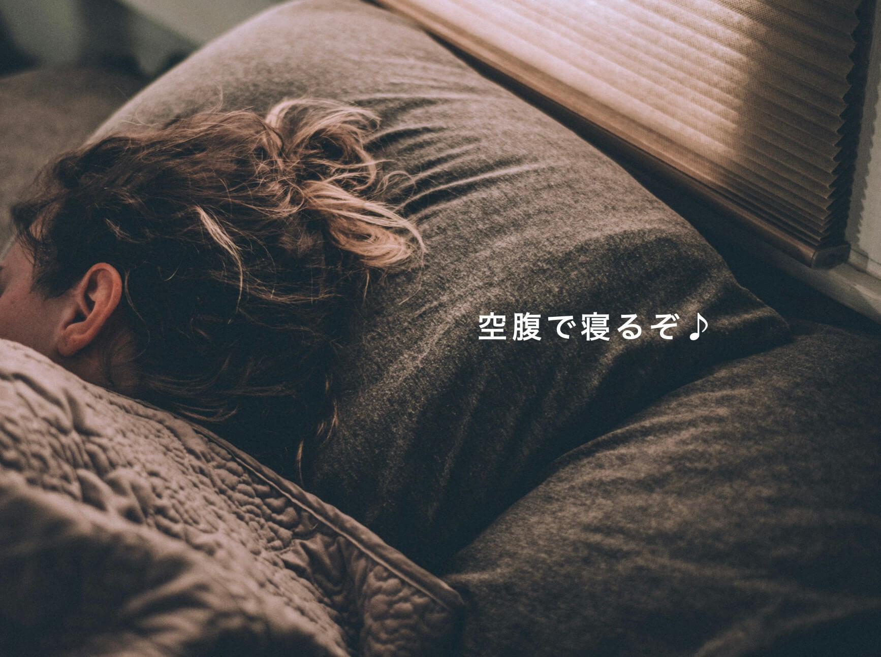 空腹で寝ている女性の写真