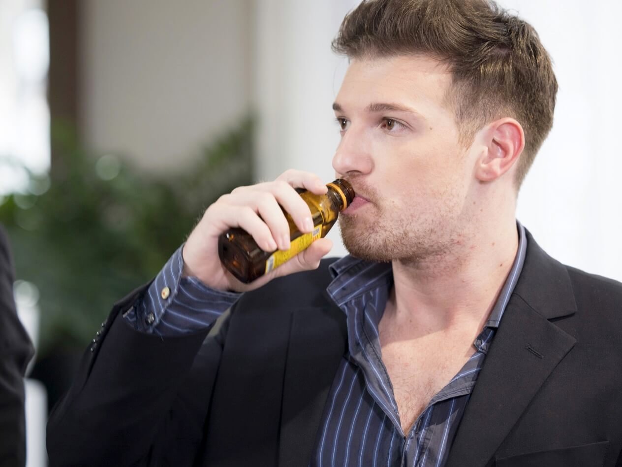 エナジードリンクを飲んでいる男性の写真