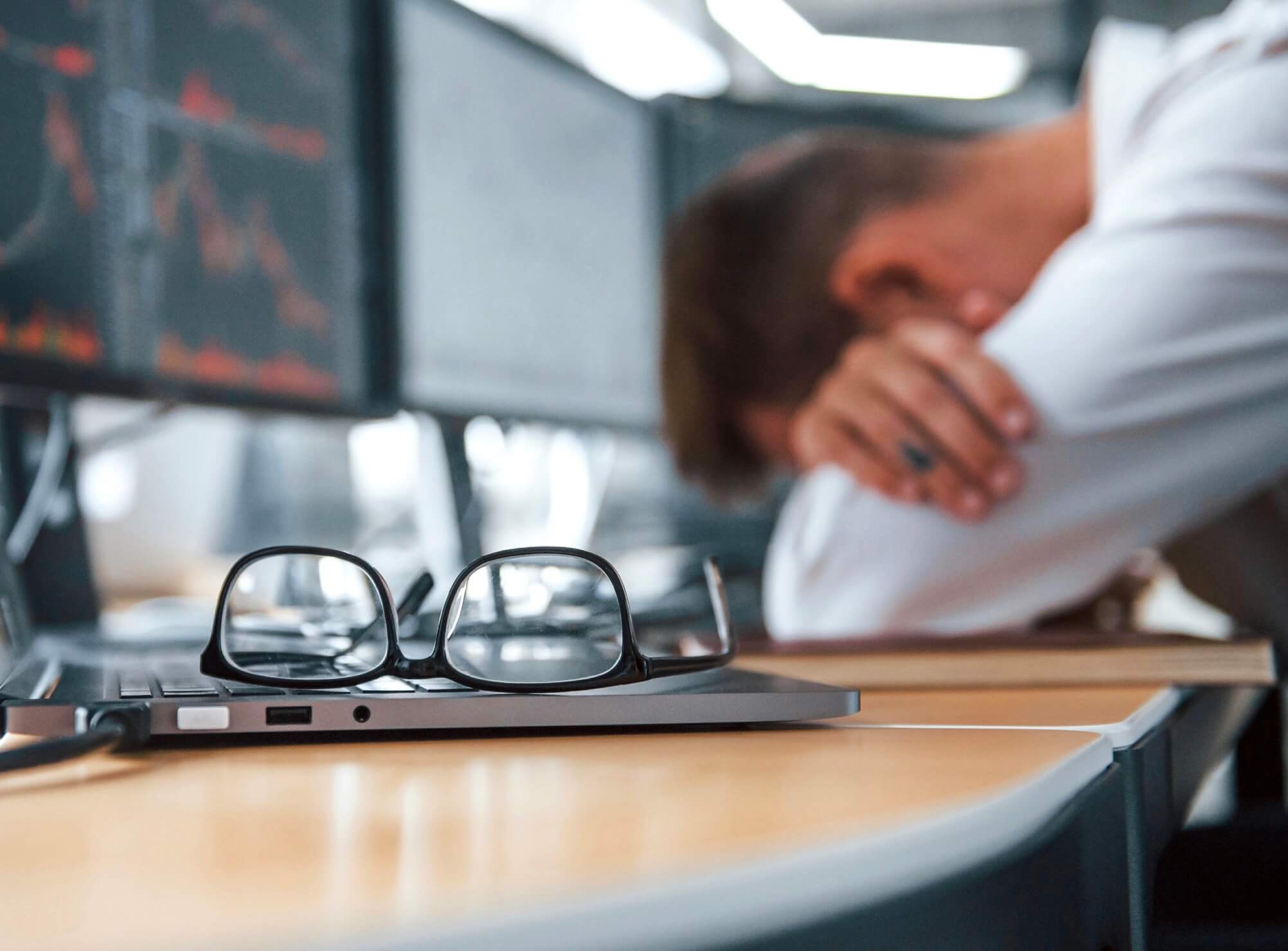 仕事中に眠くて机で寝ている男性の写真