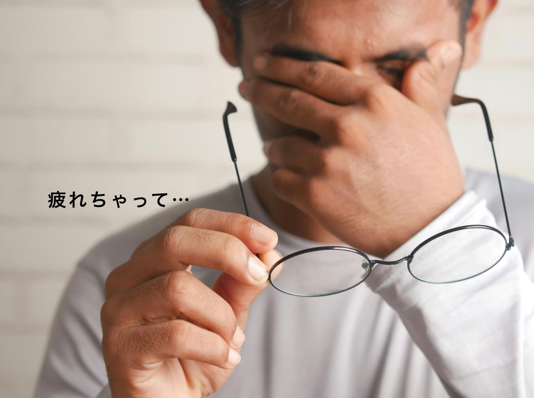 疲れて目頭をおさえている男性の写真