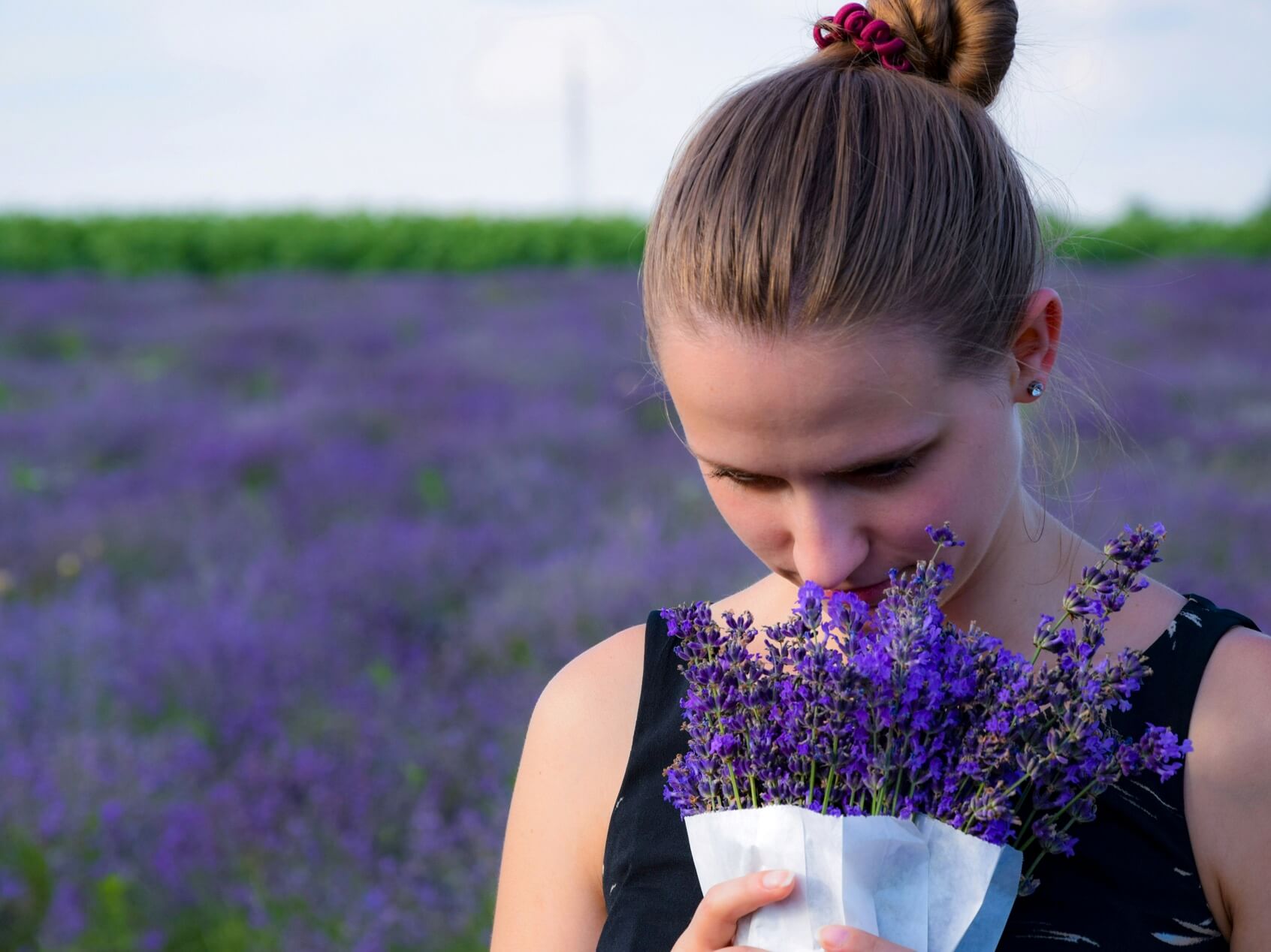 お花のニオイをかいでいる女性の写真