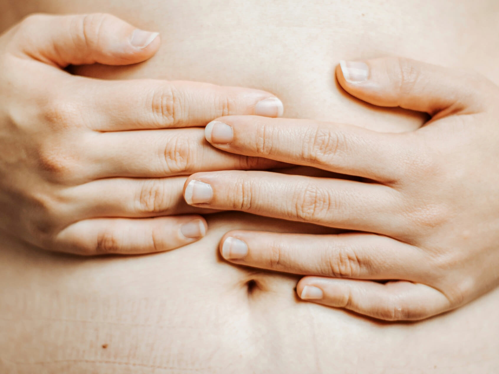 腸にガスが溜まって気持ち悪そうな女性の写真