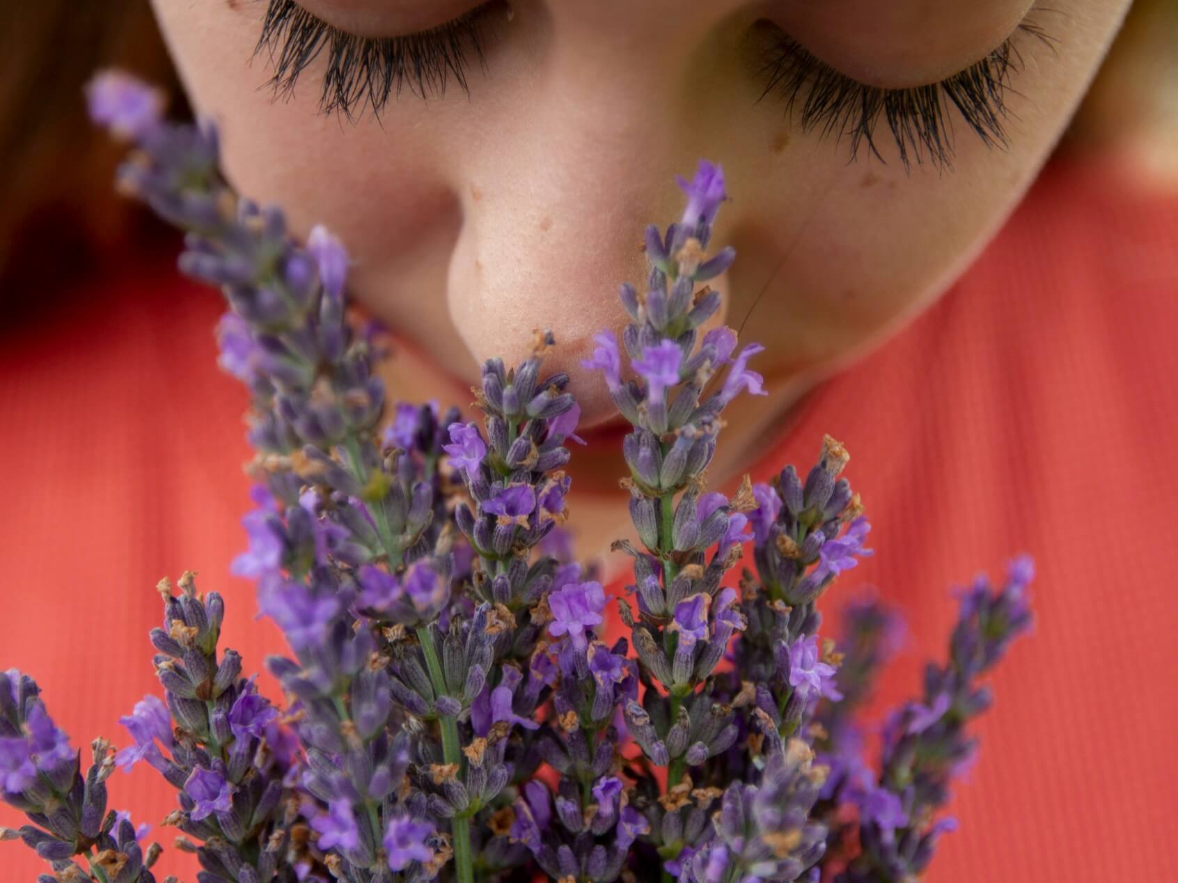 加齢臭に悩みながらお花の香を嗅ぐ女子の写真
