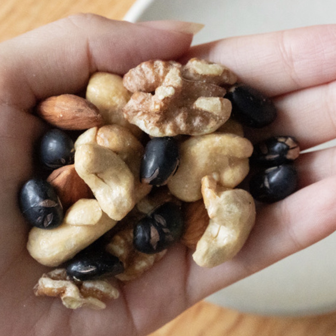 1日分に食べるオアディスワンのおきかえナッツの目安量を手に乗せているのイメージ