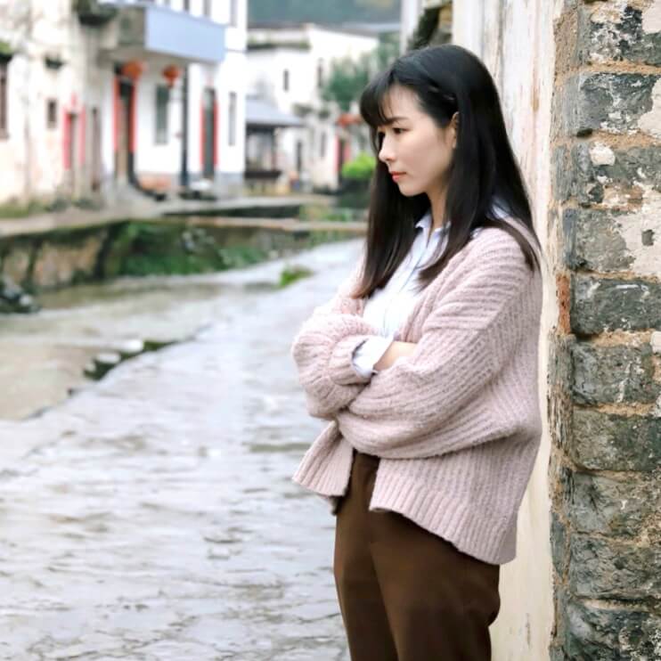 PMSでしんどそうに立っている女性の画像