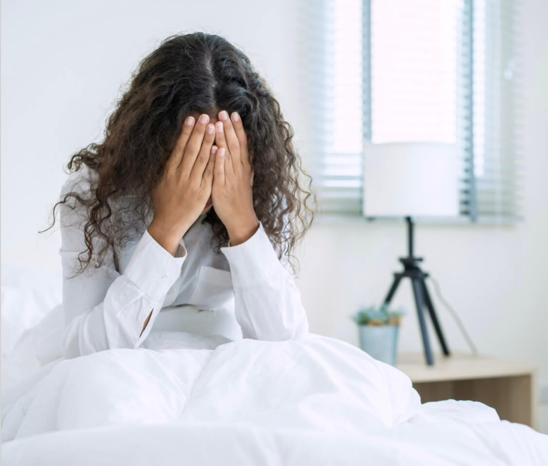 PMSのむくみで顔をおさえている女性